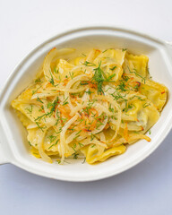 Ravioli pasta with onions. Traditional Italian cuisine concept, close up. Served in white pot over white background
