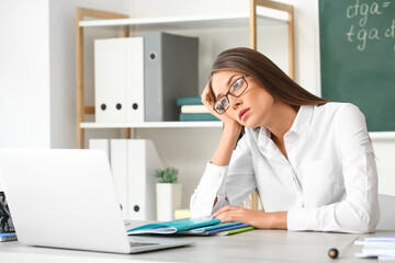 Stressed young female teacher in classroom