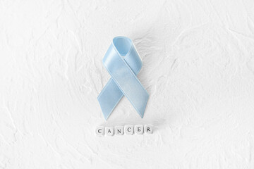 Blue ribbon and word CANCER on white background