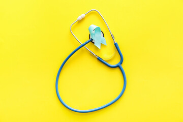 Blue ribbon and stethoscope on color background. Prostate cancer awareness concept