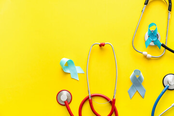 Blue ribbons and stethoscopes on color background. Prostate cancer awareness concept