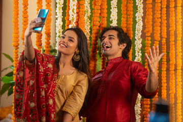 Young couple clicking a selfie together while they pose charmingly 	 - Powered by Adobe