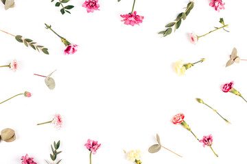 On a white background, flowers of different species are laid out in a circle, branches with beautiful leaves, blooming flowers and buds of flowers that have not opened