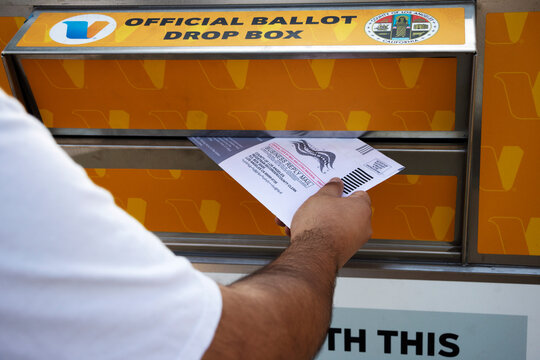 Hand inserting mail voting ballot into an official county drop box on October 17, 2020 in Los Angeles, California.