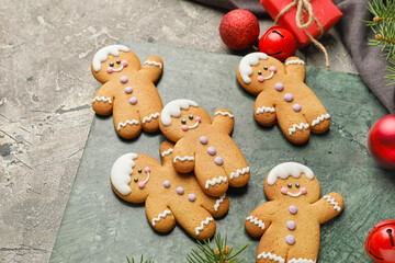 Tasty gingerbread cookies and Christmas decor on grey background