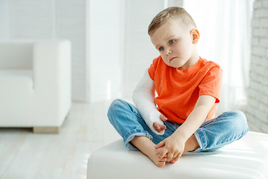 little boy in a cast.child with a broken arm. funny kid after accident. High quality photo.