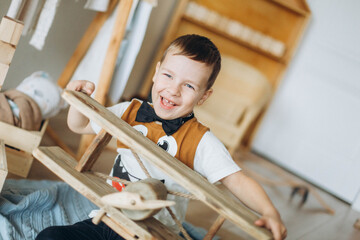 Happy little boy with wooden airplane at home. Children home activity