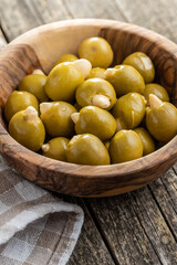 Pitted green olives stuffed with almonds in bowl.