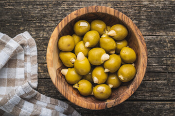 Pitted green olives stuffed with almonds in bowl.
