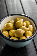 Pitted green olives stuffed with almonds in bowl.