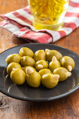 Pitted green olives stuffed with almonds on plate.