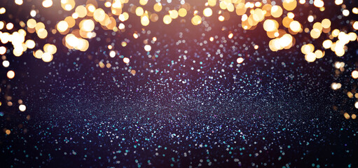 Abstract blue Christmas glowing background with shiny gold defocused lights, bokeh