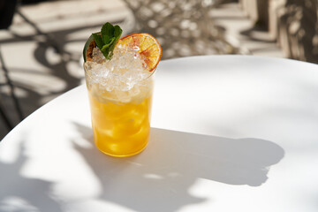 Cocktail Tropicana with dried orange slice and mint leaf