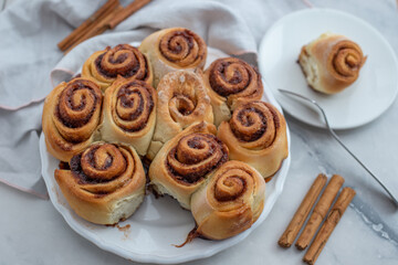 Cinnamon rolls with sugar frosting. With cinnamon sticks and spices, wooden background