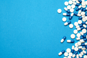 group of pills or capsules on blue background