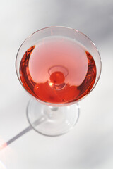 Red cocktail in martini glass with cherry. Exotic alcoholic cocktail