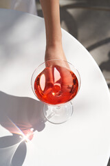 Red cocktail in martini glass with cherry. Exotic alcoholic cocktail