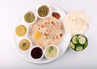 Vegetable Gujarati kathiyawadi thali on table, Full Gujarati dish mouth watering, traditional dishes,  indian Meal is a combination of different kinds of dals, sweet dishes, rice and roti.