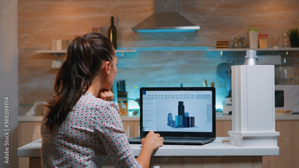 Poster designer using cad software to design a 3d concept of buildings working remotely overtime from home.