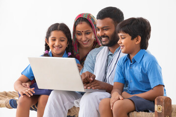 PORTRAIT OF A RURAL FAMILY USING A LAPTOP
