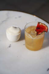 Bee gross cocktail with pineapple slice and whipped cream.