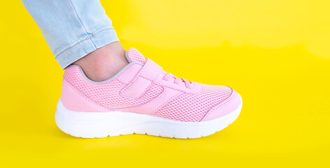pink sneakers and blue jeans on a yellow background. Mockup. Copy space