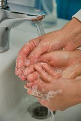 Fototapeta premium Close up mother helping little girl to wash her hands to prevent virus and germs. Covid