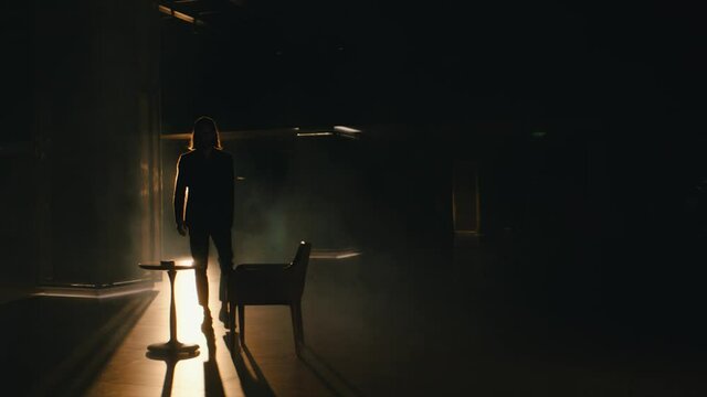 stylish man sits at a table in an empty hall