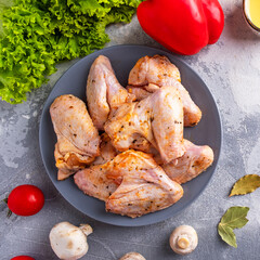 Raw marinated chicken wings on a plate. Copy space