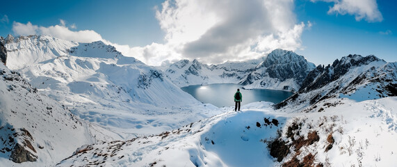 Hiking on snowshoes on a trail. Man trekking in snow covered mountain landscape overlooking...