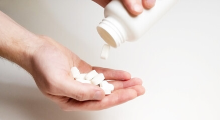 White pills are falling into hands. Medical concept.
