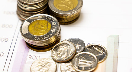 Business and Finance Concept: Stacked silver and golden coins on graphic chart.