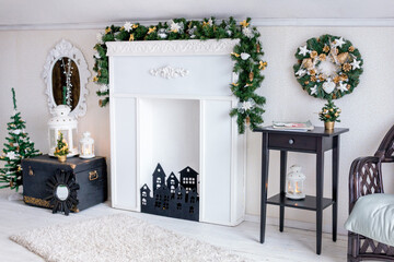 Christmas decor. White and black decorations with an emphasis on green and gold. 
White room with fireplace