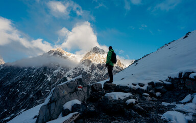 Hiker or alpinist at the top of a mountain. A success of mountaineer reaching the summit. Outdoor...