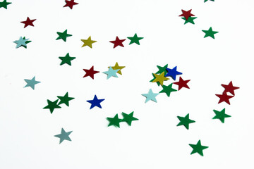 Fototapeta premium Confetti of colorful stars on a white table, festive pattern