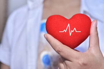 Soft focus of red heart with electrocardiogram in heart diseases patient's hand. Complications of...