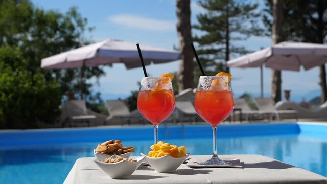 Aperitivo a bordo piscina, bicchiere di Spritz con salatini