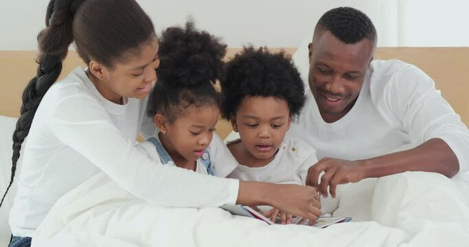 Father and Mother reading stories to child at bedroom. Quality family time. Family, Lifestyle, Education and Holiday concept.