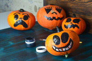 Funny pumpkins decorated with faces for the Halloween holiday. Celebrate a holiday with decorative pumpkins, copy space for text