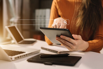 Business women clicking internet search page on computer and tablet touch screen in office.
