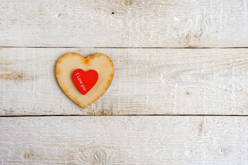 Two hearts, red and wooden on an old white background. Text I love you. Valentine day.