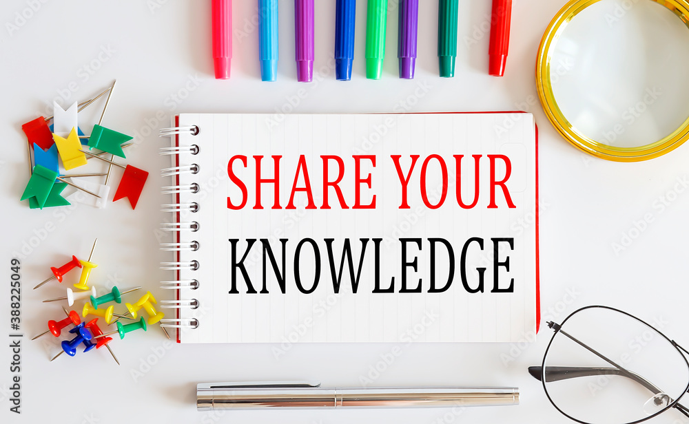 Aufkleber notebook with share your knowledge word with office tools on the white table.