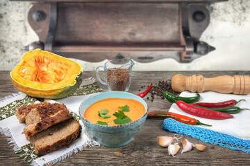 Pumpkin soup with brad onions and red pepper on the wooden table