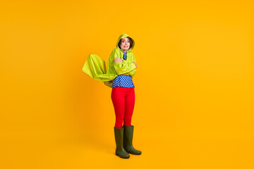 Full length photo portrait of shivering woman hugging self with hood on isolated on vivid yellow colored background