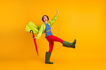 Full length photo portrait of woman walking kicking standing on one leg isolated on bright yellow colored background