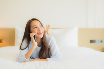 Portrait beautiful young asian woman use smart mobile phone on bed