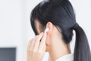 ワイヤレスイヤホンをつける女性