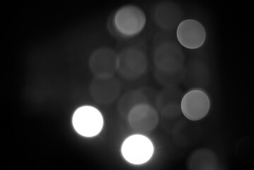 Blurry light circles background in black and white. Black abstract background in blur.