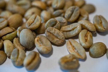 raw coffee beans are on a table.