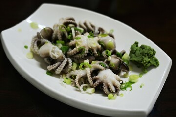 Close-up of a plate of boiled octopus with mustard.